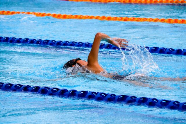 persona nadando en una piscina olímpica